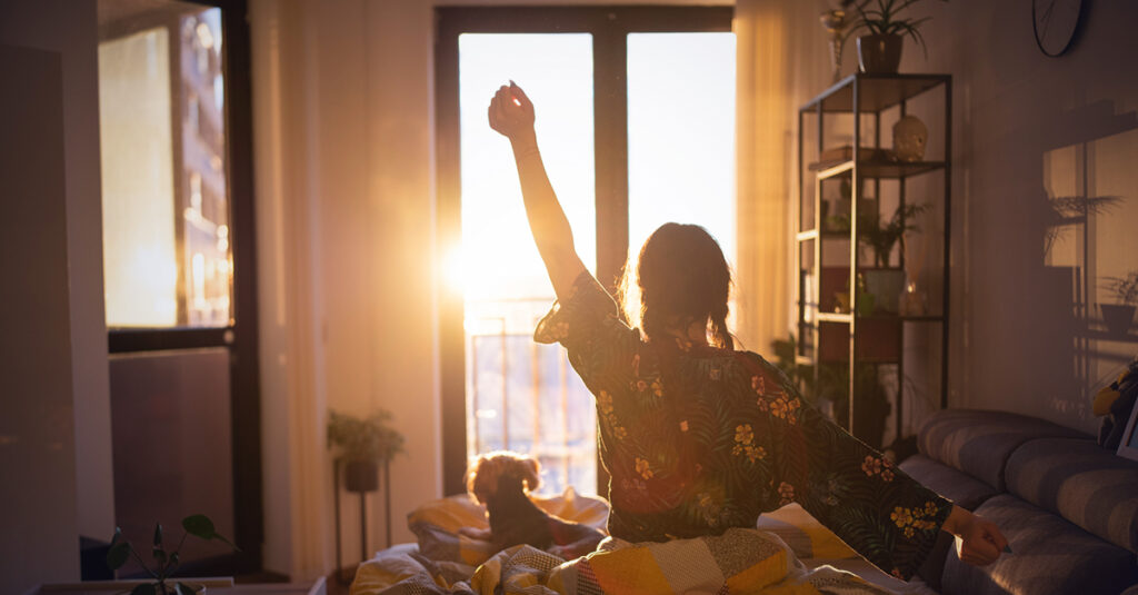 Veteran stretches in morning sunlight feeling rested after improved sleep quality.
