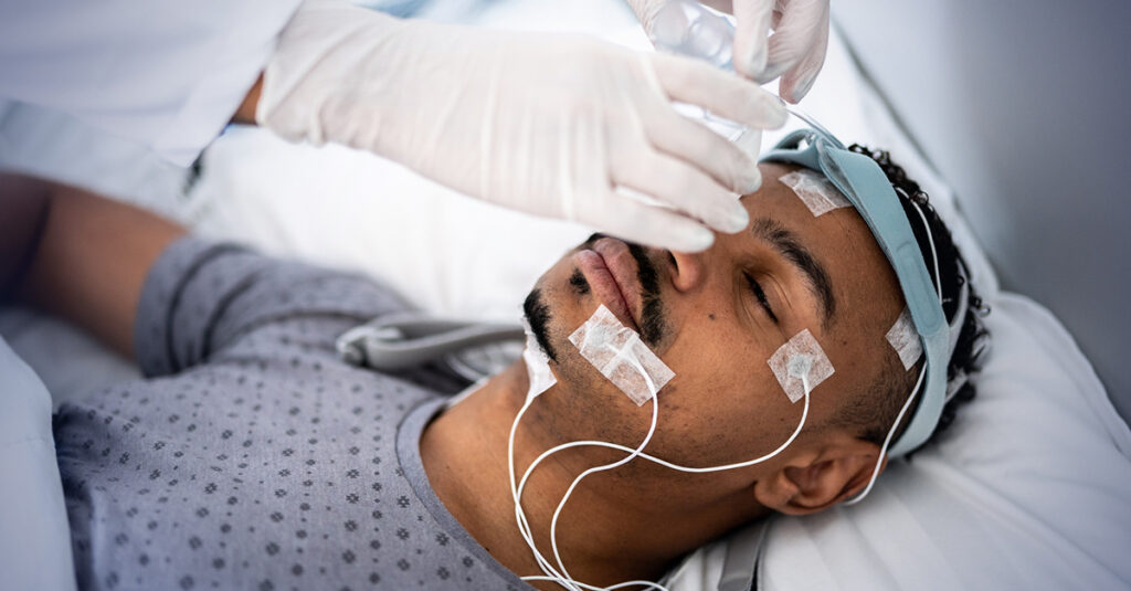 Veteran participates in medical sleep test with sensors to track breathing patterns.