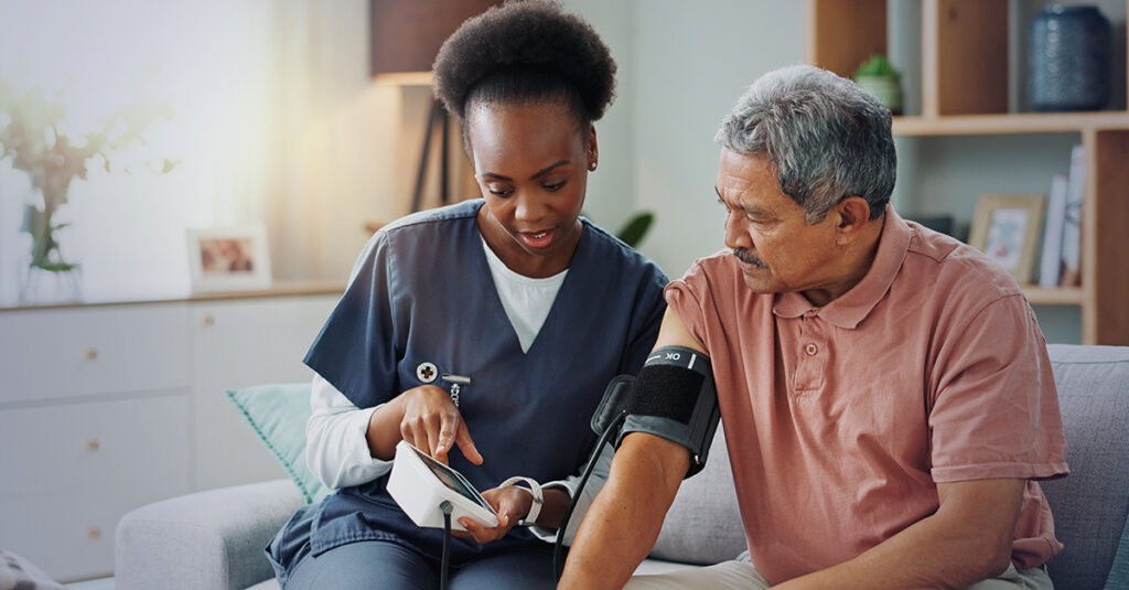 Nurse checking a veteran’s blood pressure at home.