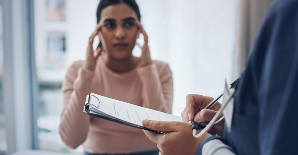 Veteran being evaluated for migraine symptoms by a medical professional.