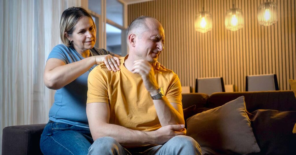 Wife massaging tension out of her veteran husband.